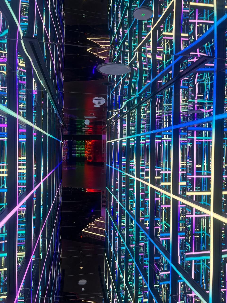 Neon hallway with multi-colour LED grid creating infinite depth